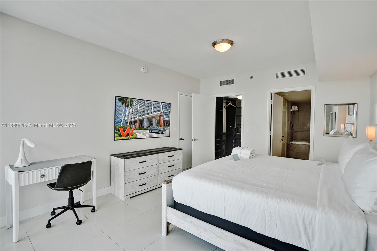 485 Brickell Avenue, Unit 4207 Miami, FL 33131 - Photo 14 of 41 a bedroom with a bed and a dresser in it