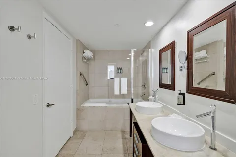 a bathroom with a tub sink and mirror
