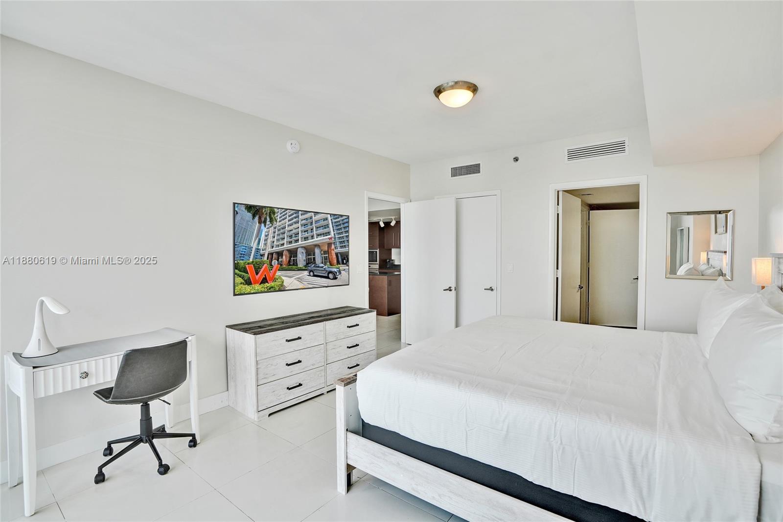 485 Brickell Avenue, Unit 4207 Miami, FL 33131 - Photo 19 of 41 a bedroom with a bed and a lamp on table