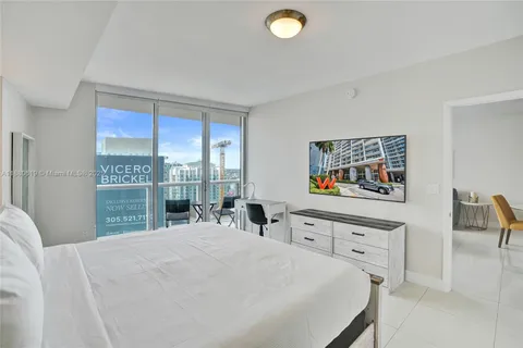 a bedroom with a bed and a large window