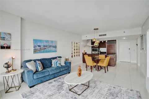 a living room with furniture and kitchen view