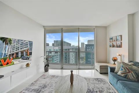 a living room with furniture and a floor to ceiling window