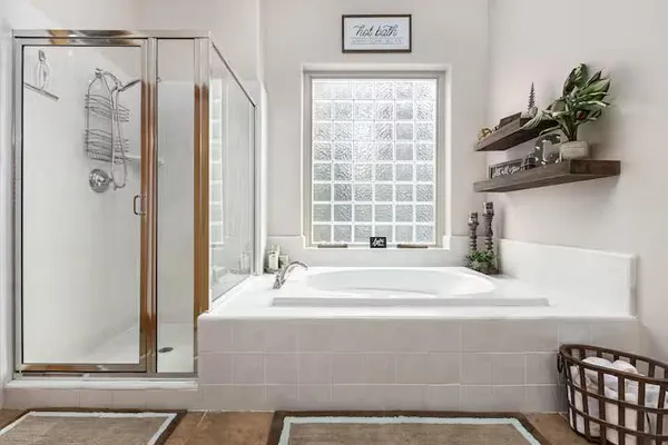 a bathroom with a granite countertop tub sink and mirror