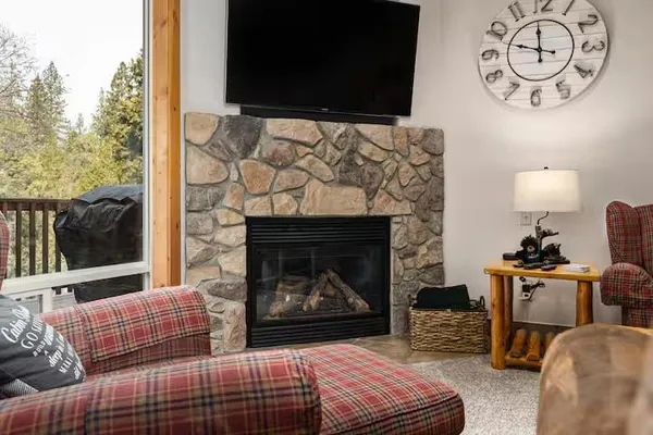 a living room with couches fireplace and a flat screen tv