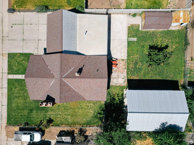 673 East 700 South Springville, UT 84663 - Photo 8 of 43 Aerial perspective showcasing a multi-gabled roofline, an expansive concrete driveway, a separate outbuilding with a metal roof, a secondary structure with a gabled roof, and a mature tree within the grassy yard