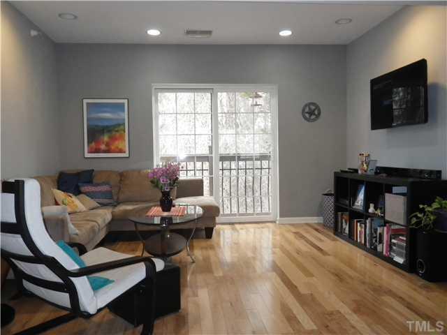 720 Bilyeu Street, Unit 304 Raleigh, NC 27606 - Photo 4 of 10 a living room with furniture and a flat screen tv
