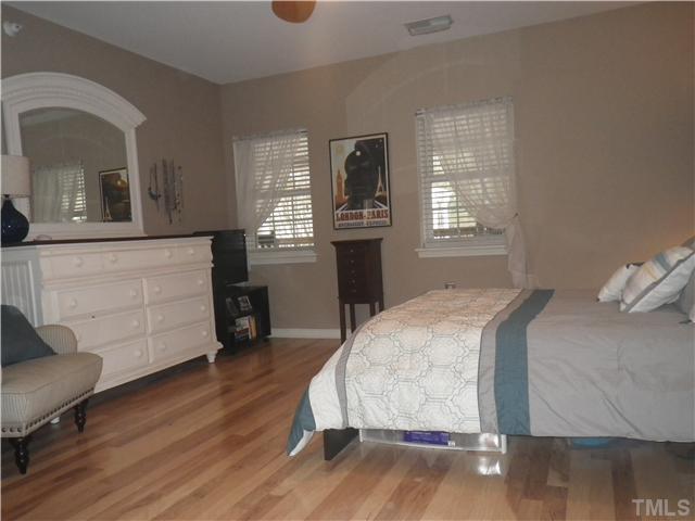720 Bilyeu Street, Unit 304 Raleigh, NC 27606 - Photo 6 of 10 a bedroom with a bed and a dresser