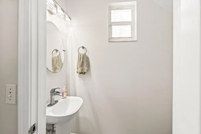 a bathroom with a sink and mirror with window