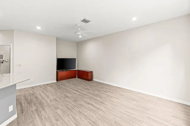 a view of an empty room with wooden floor