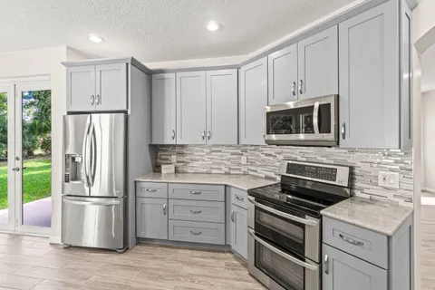 a kitchen with stainless steel appliances a stove microwave and refrigerator