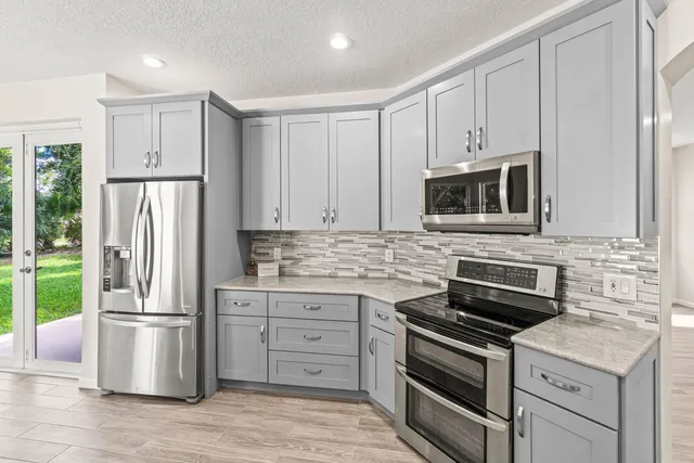 a kitchen with stainless steel appliances a stove microwave and refrigerator