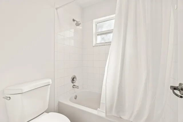 a white toilet sitting next to a bath tub