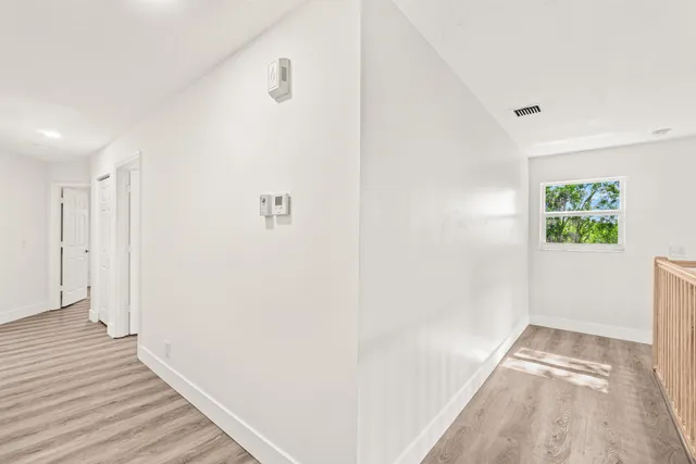 a view of a hallway with wooden floor