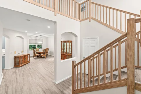a view of an entryway wooden floor and a kitchen view