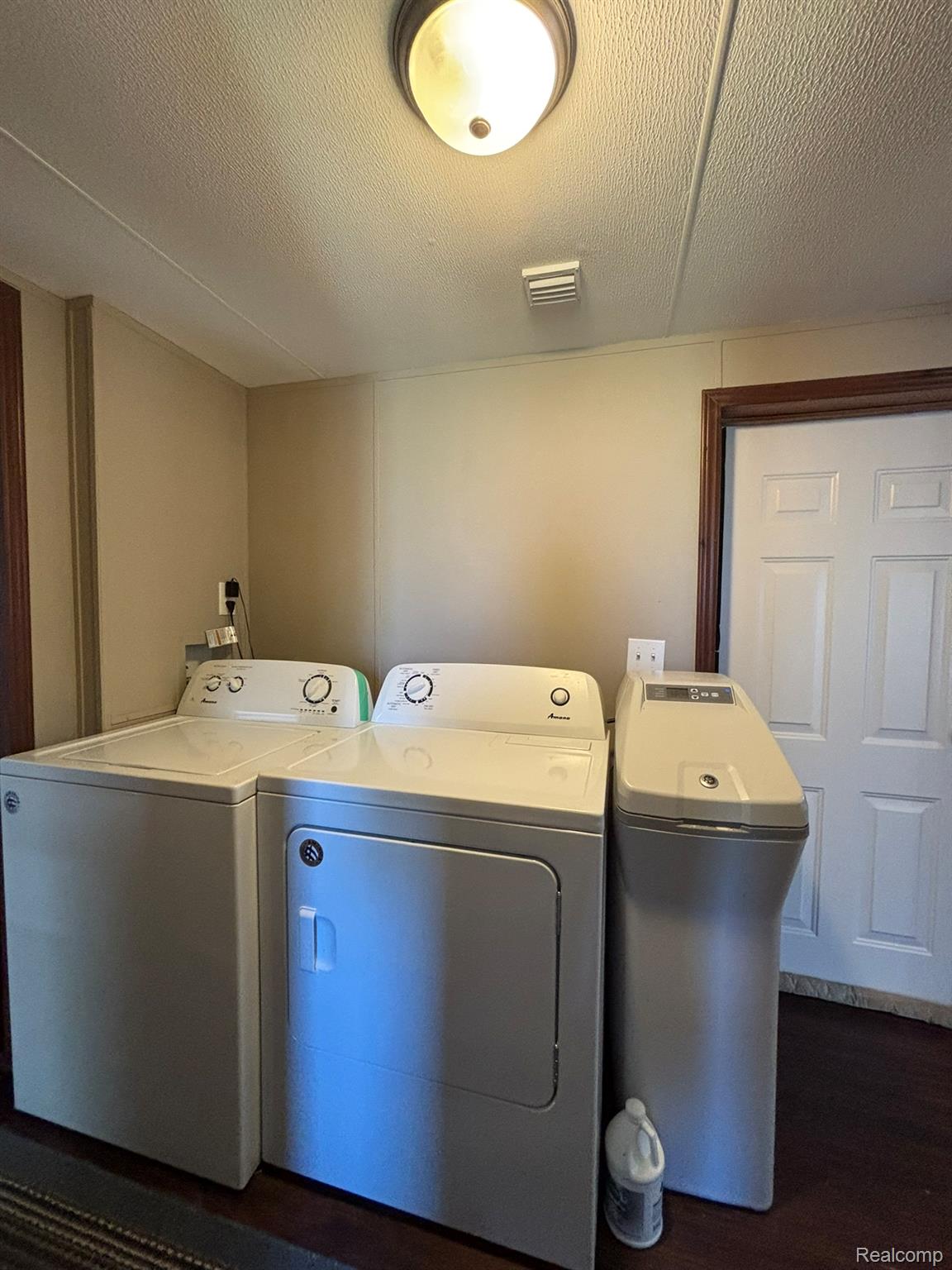 246 South Sheridan Road Lennon, MI 48449 - Photo 12 of 14 Dedicated utility space featuring a washer and dryer unit, dark wood-finish flooring, neutral wall paneling, and a flush-mount ceiling light fixture