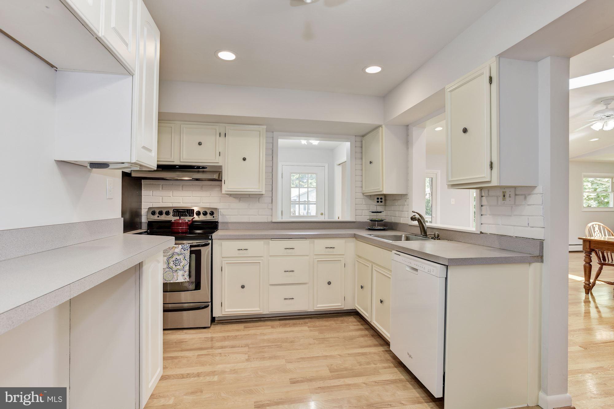 3618 Macalpine Road Ellicott City, MD 21042 - Photo 5 of 30 a kitchen with granite countertop a sink stove a refrigerator and white cabinets