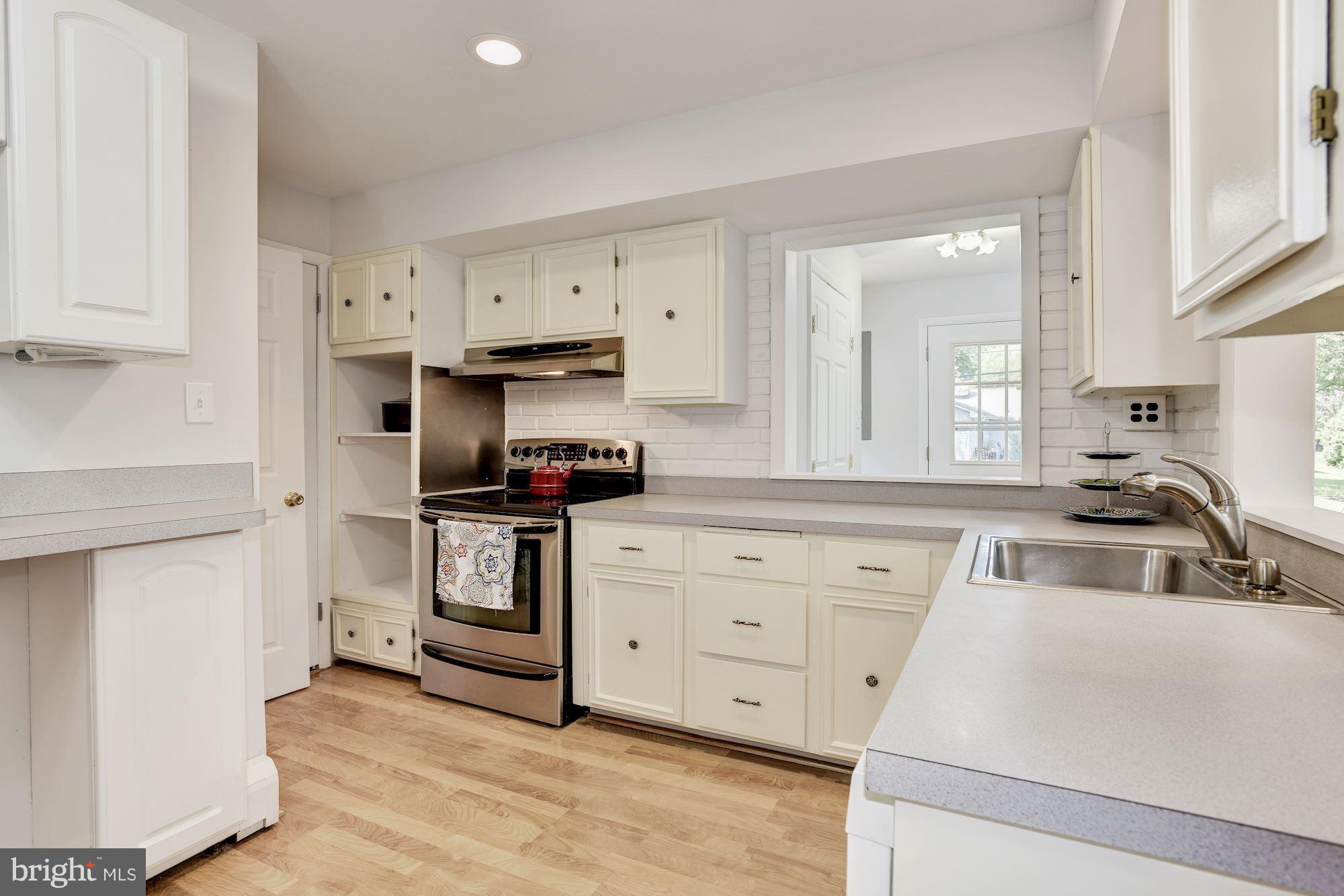 3618 Macalpine Road Ellicott City, MD 21042 - Photo 6 of 30 a kitchen with white cabinets and stainless steel appliances