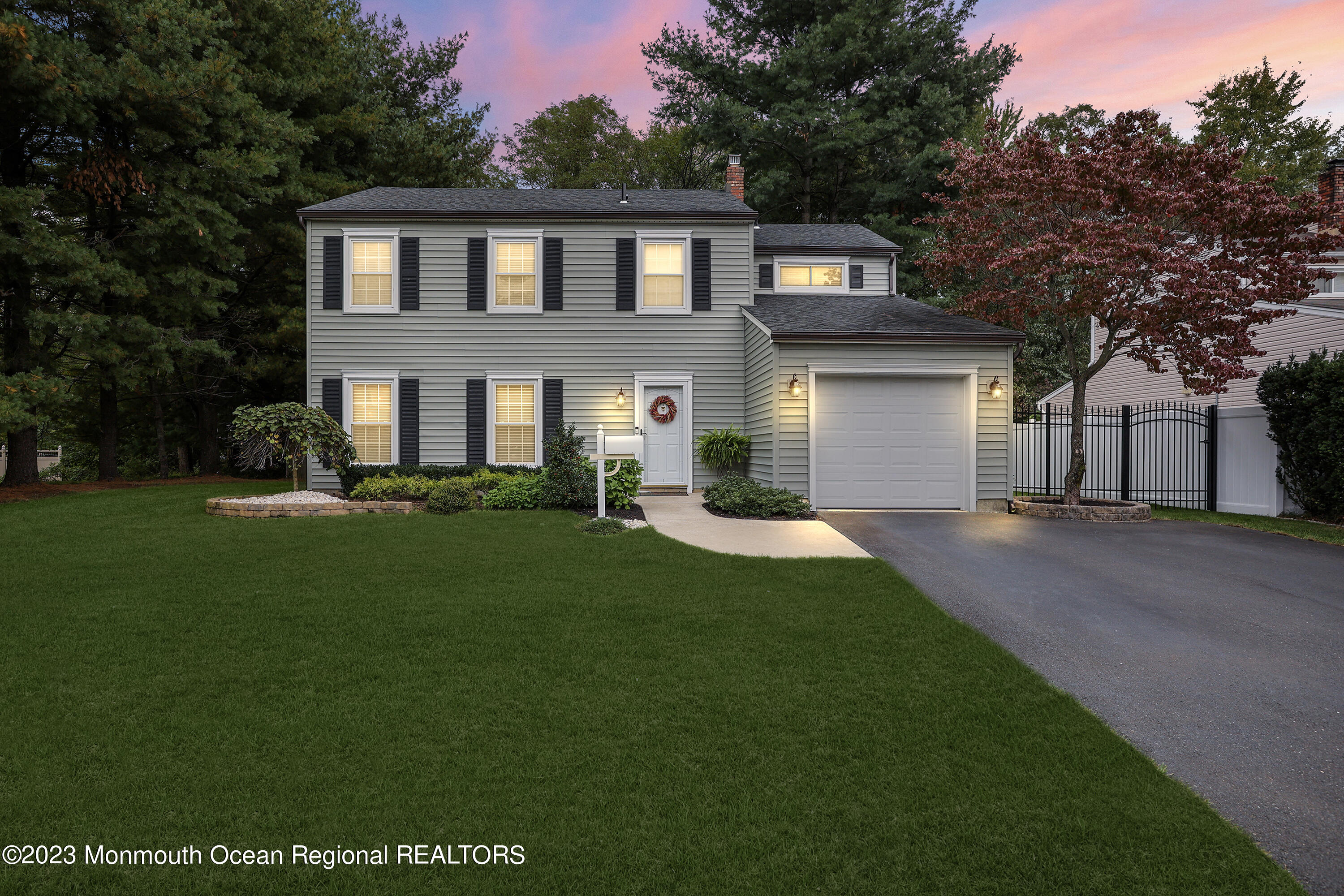 a front view of a house with a garden and yard