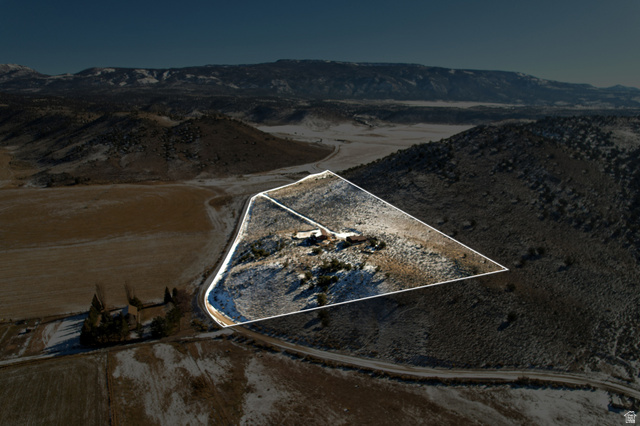 Aerial view of property and surrounding area featuring property boundaries highlighted and mountains