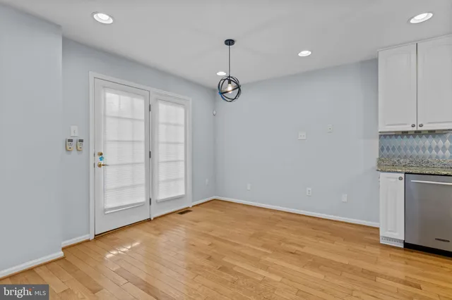 a view of empty room with wooden floor and cabinet