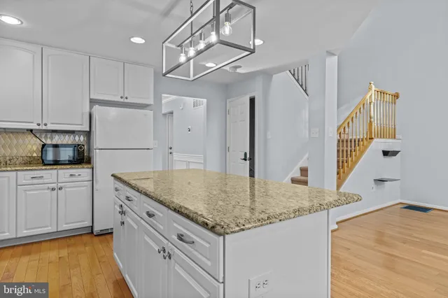 a kitchen with kitchen island cabinets and wooden floor