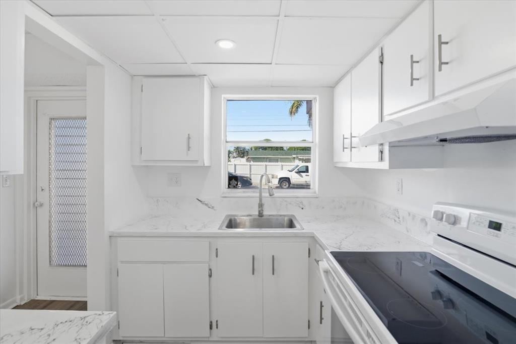 4161 Northwest 26th Street, Unit 105 Lauderhill, FL 33313 - Photo 12 of 26 a kitchen with cabinets appliances a sink and a window