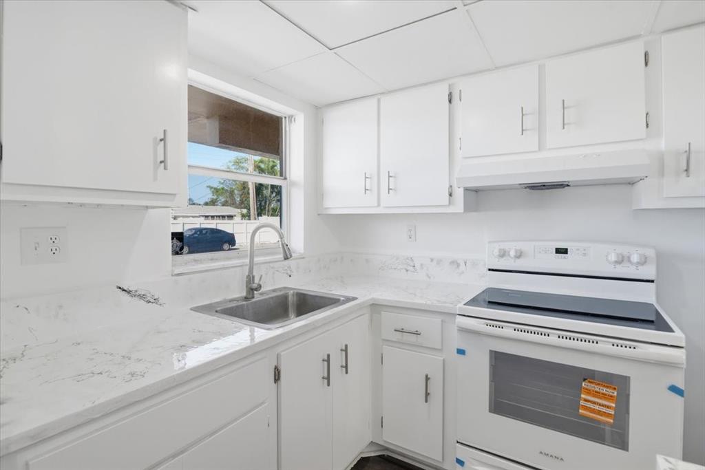 4161 Northwest 26th Street, Unit 105 Lauderhill, FL 33313 - Photo 9 of 26 a kitchen with granite countertop white cabinets and a stove