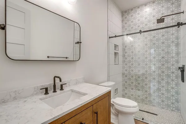 a bathroom with a sink a toilet and shower