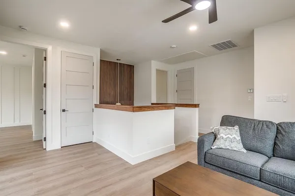 a living room with furniture and a ceiling fan