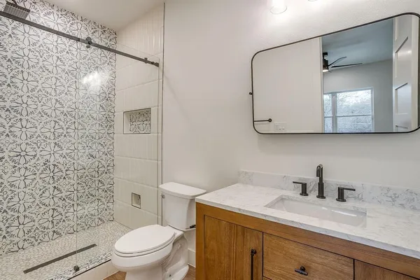 a bathroom with a sink a toilet and shower