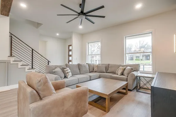 a living room with furniture a ceiling fan and a window