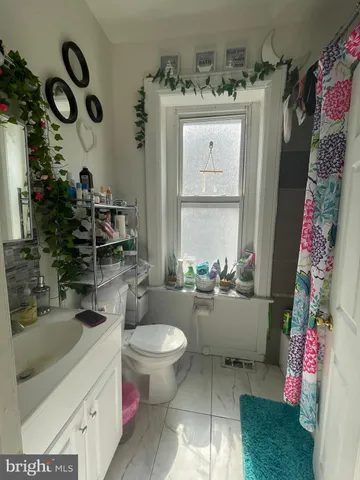 a bathroom with a sink mirror vanity and toilet