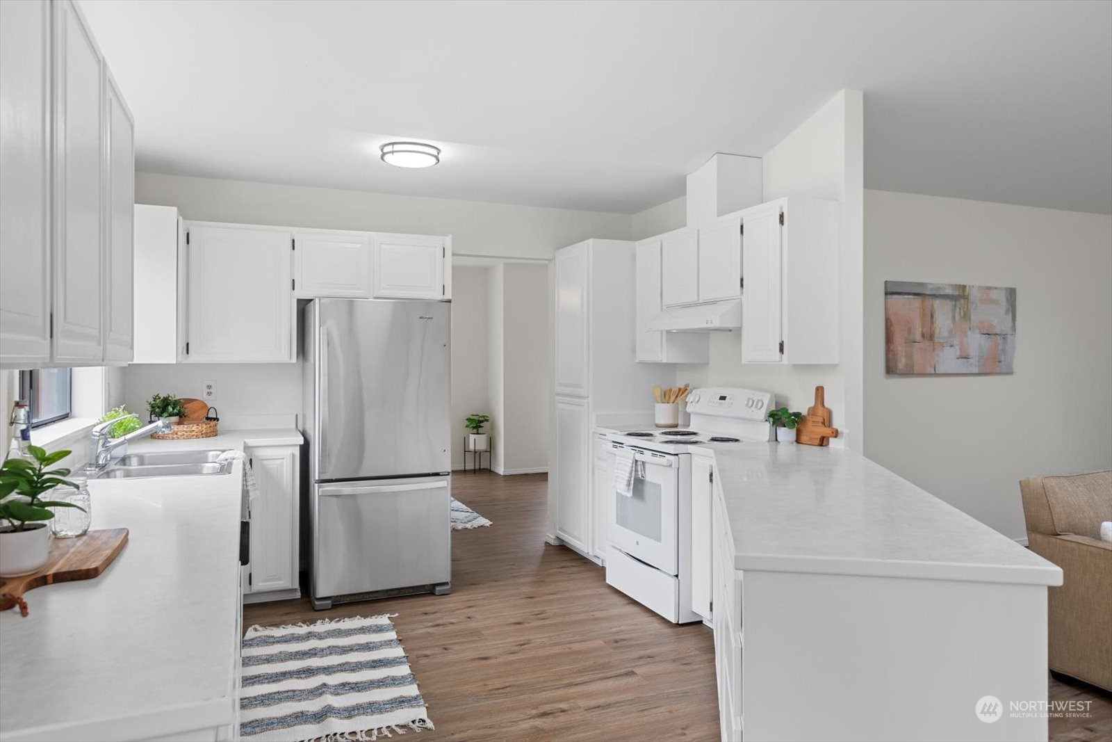 2480 215th Place Southwest Brier, WA 98036 - Photo 20 of 40 a kitchen with a refrigerator a stove and white cabinets