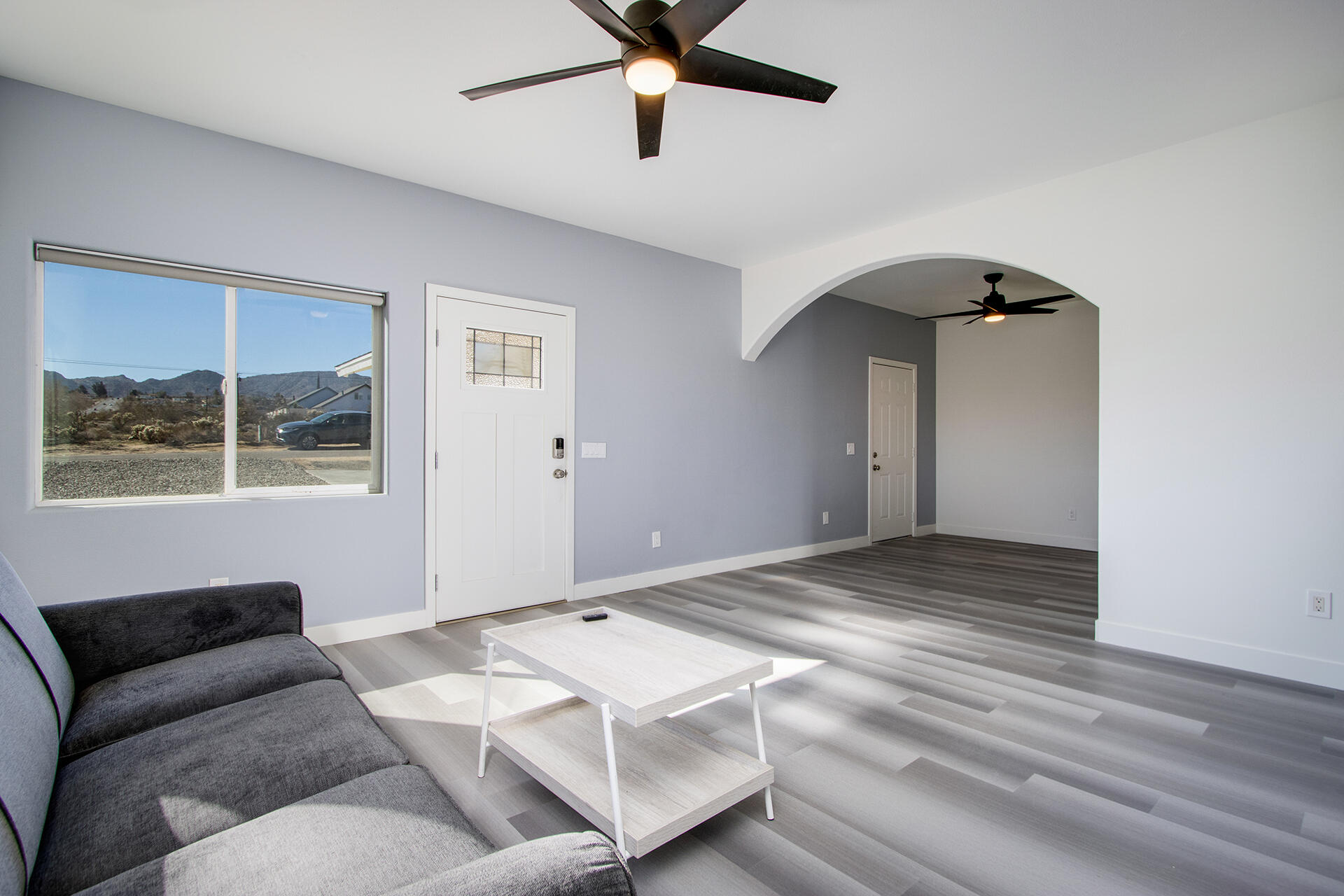 61786 Desert Air Road Joshua Tree, CA 92252 - Photo 11 of 54 a view of a livingroom with a ceiling fan and wooden floor