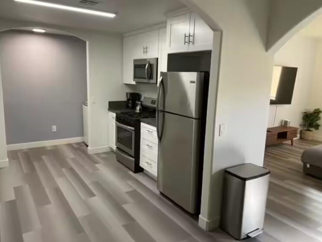 61786 Desert Air Road Joshua Tree, CA 92252 - Photo 13 of 54 a kitchen with stainless steel appliances a refrigerator stove and microwave
