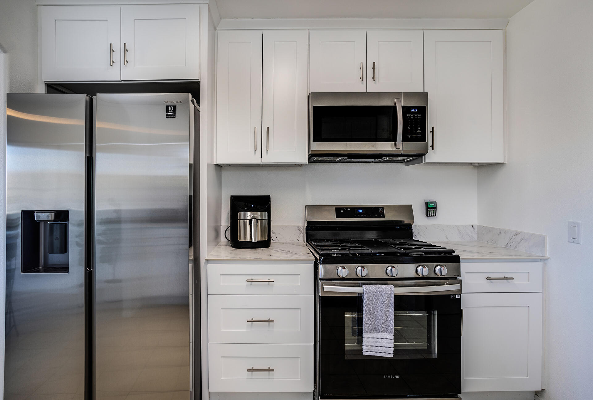 61786 Desert Air Road Joshua Tree, CA 92252 - Photo 39 of 54 a kitchen with stainless steel appliances a stove a microwave and a refrigerator