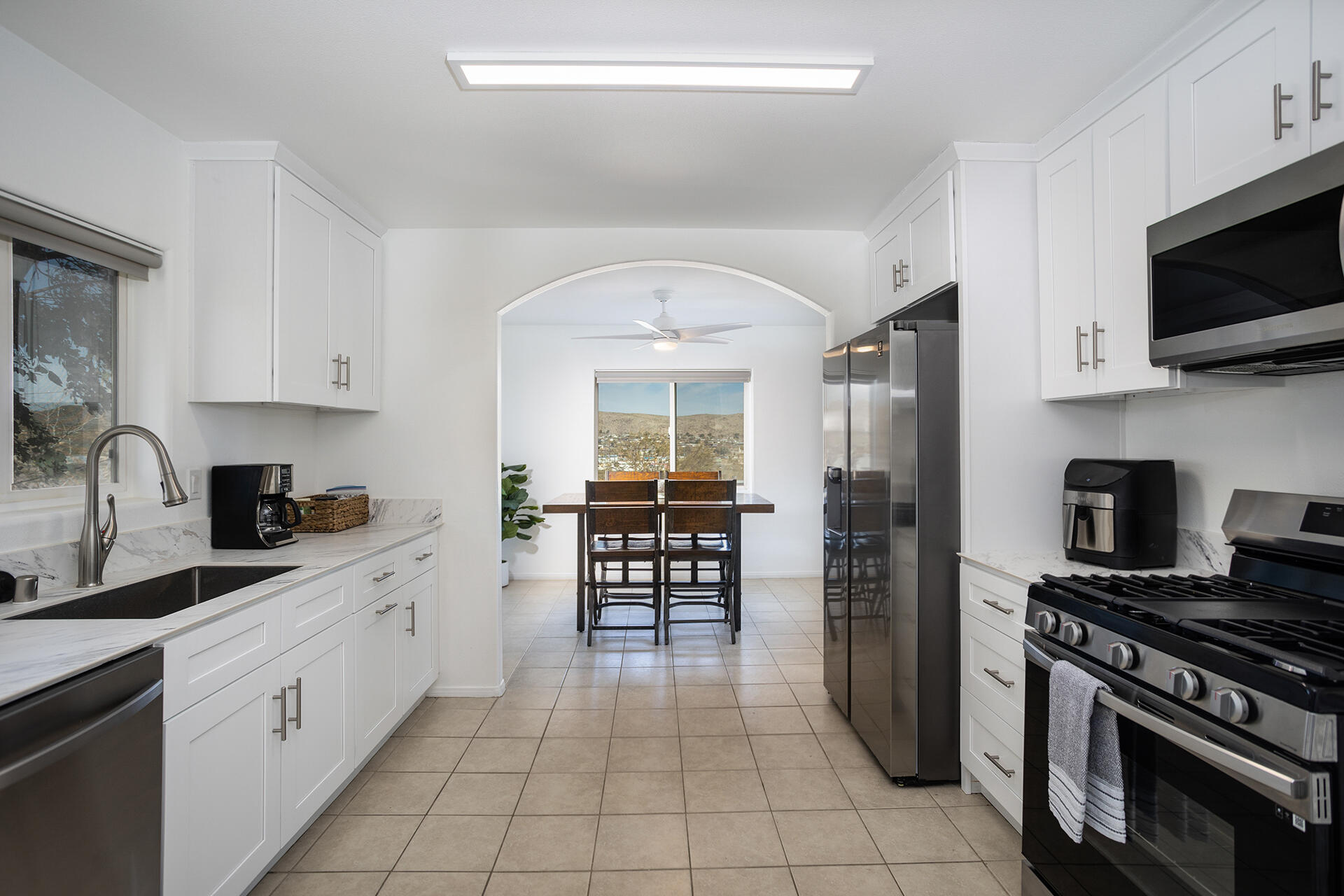 61786 Desert Air Road Joshua Tree, CA 92252 - Photo 40 of 54 a kitchen with a stove a sink and a microwave