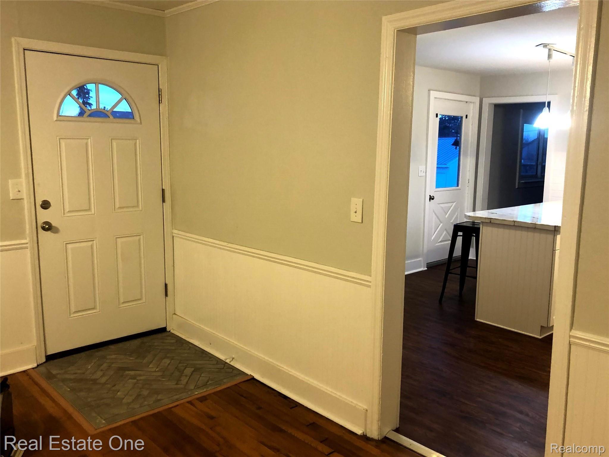 Front Door, new custom tile and original hardwood floor.  Entrance into newly remodeled kitchen with vinyl floor