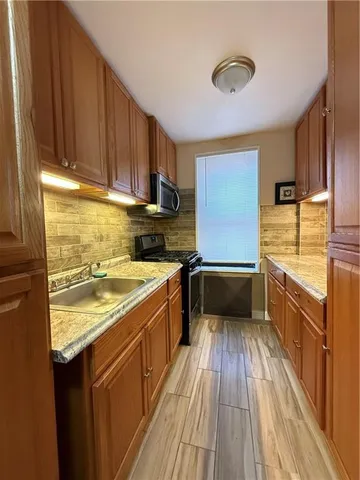 a kitchen with a sink and wooden floor