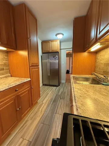 a kitchen with stainless steel appliances granite countertop a refrigerator and a stove