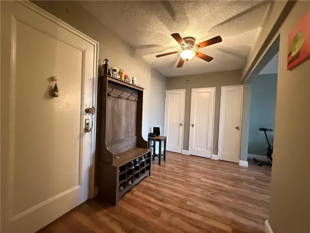 a view of a hallway with wooden floor and staircase