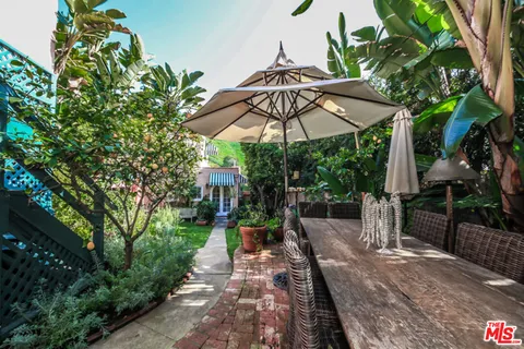 a view of a patio with table and chairs under an umbrella