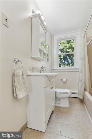 a bathroom with a sink toilet and window