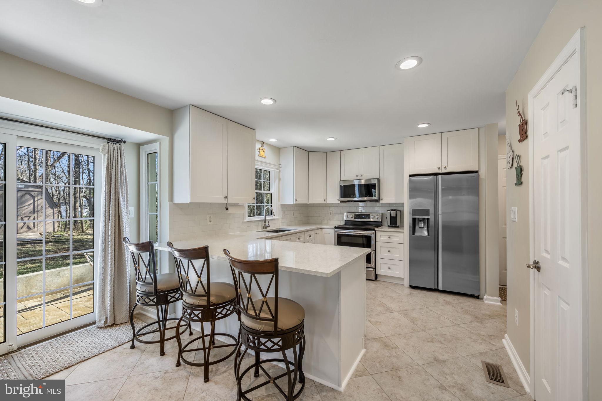 8504 Silverdale Road Lorton, VA 22079 - Photo 12 of 48 a kitchen with stainless steel appliances kitchen island granite countertop a refrigerator and cabinets