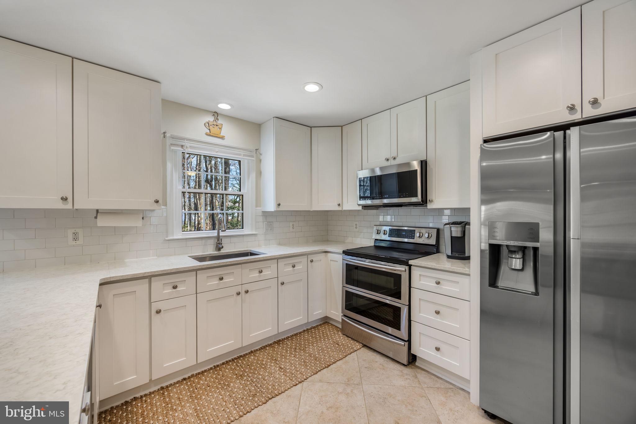 8504 Silverdale Road Lorton, VA 22079 - Photo 13 of 48 a kitchen with white cabinets stainless steel appliances and sink