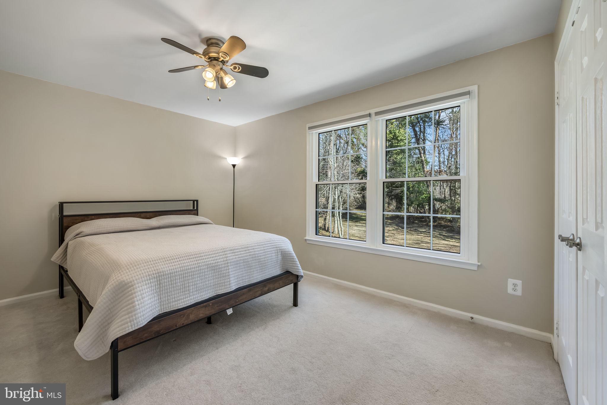 8504 Silverdale Road Lorton, VA 22079 - Photo 30 of 48 a spacious bedroom with a bed and a ceiling fan