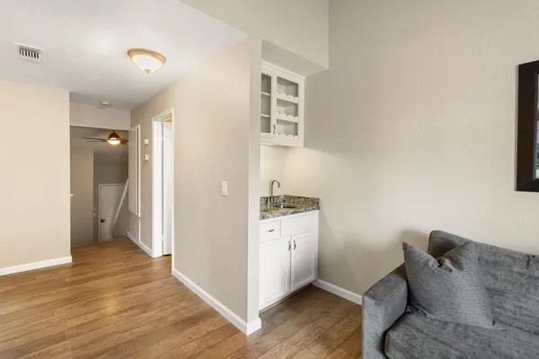 a hall with wooden floor and cabinets