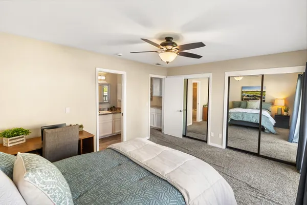 a bedroom with a bed dresser and a large mirror