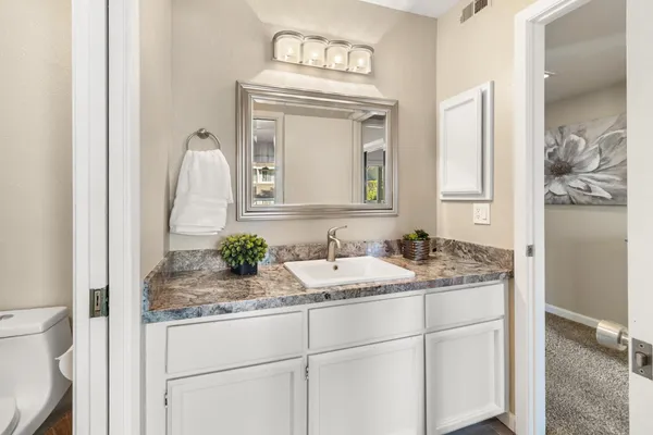 a bathroom with a granite countertop sink and a mirror
