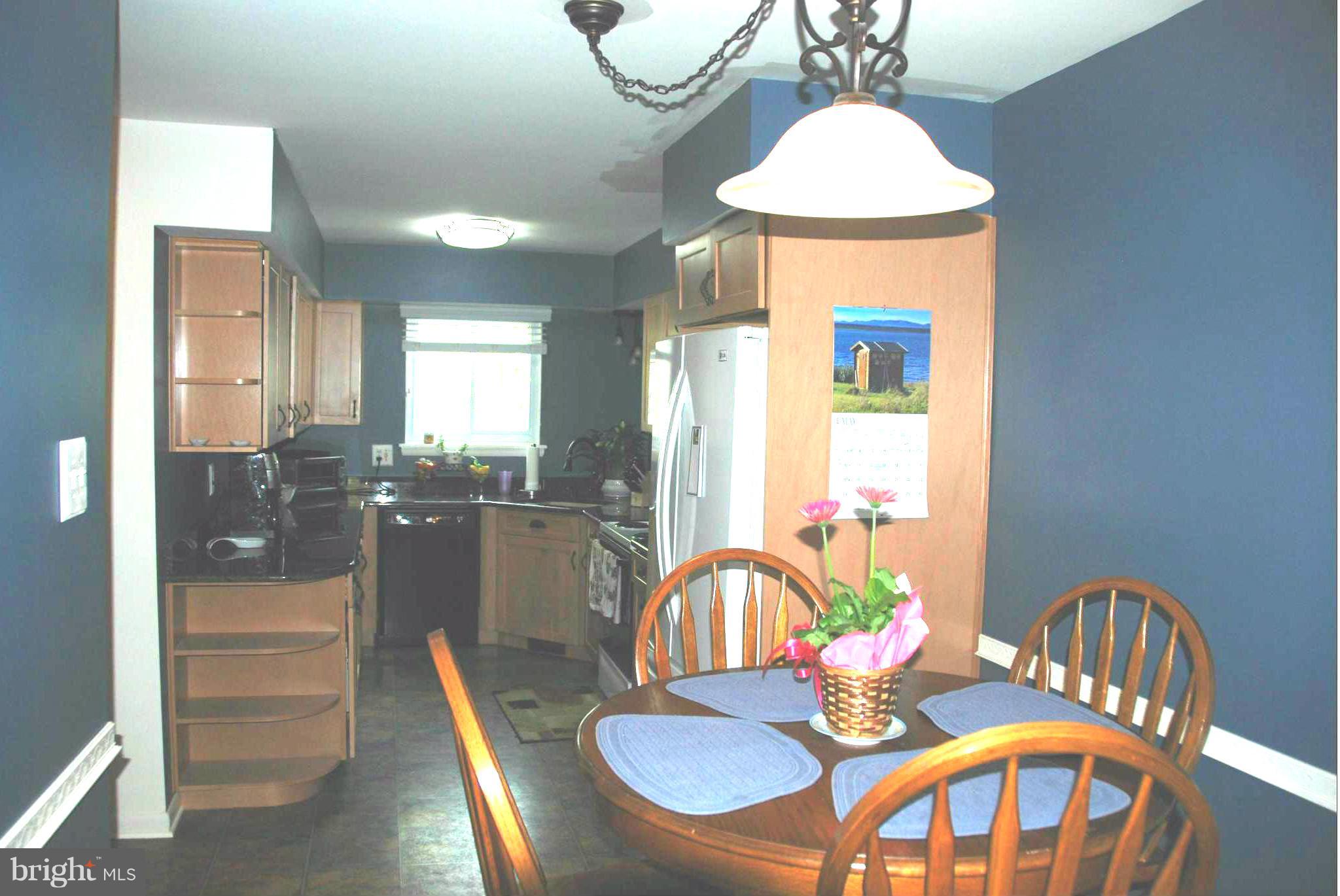 11019 Saffold Way Reston, VA 20190 - Photo 4 of 22 a dining room with furniture a chandelier and wooden floor
